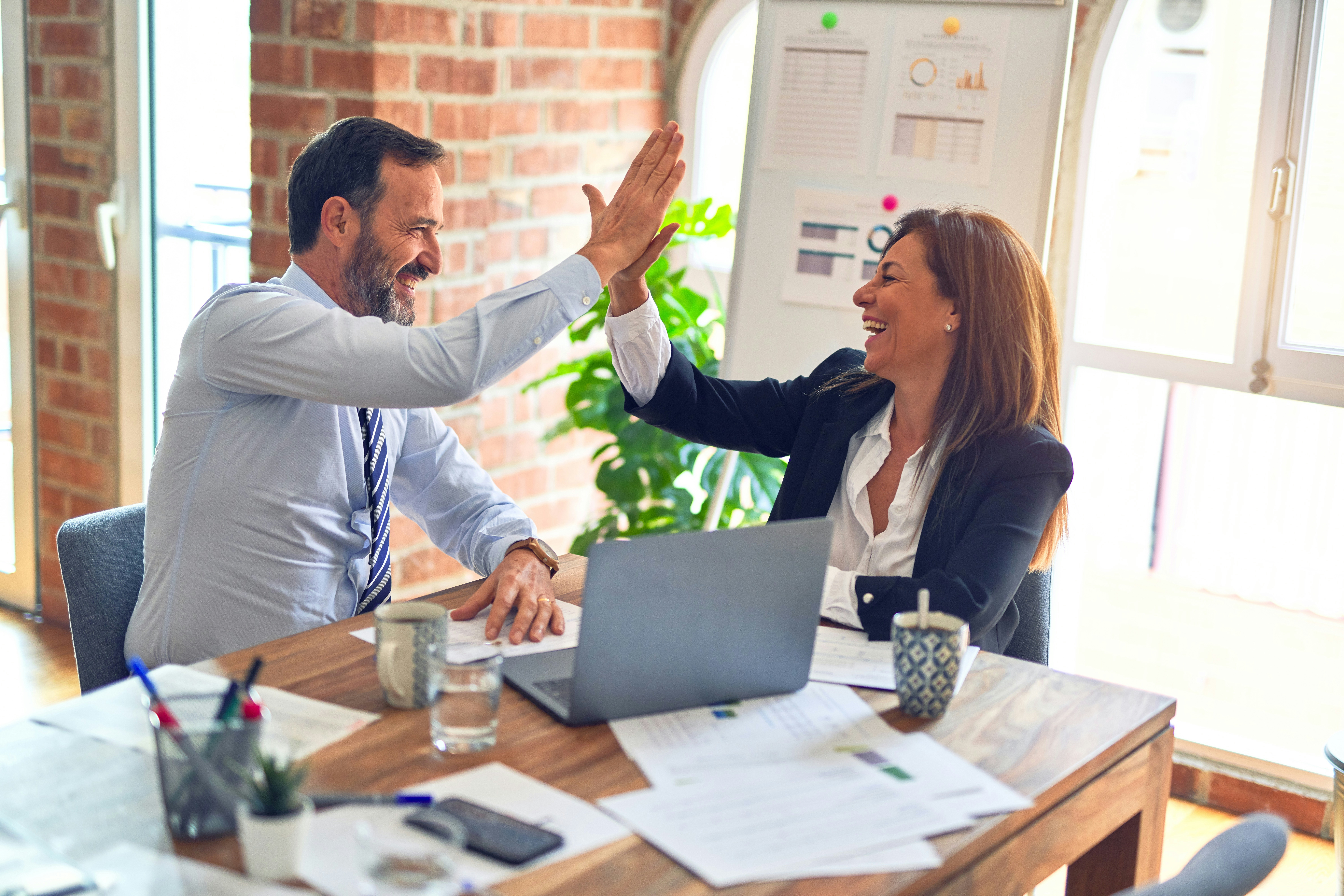 A BCW  marketer and her client doing a high-five after a successful meeting